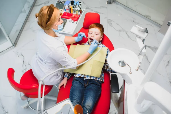 Dentysta Dziecięcy Badający Małe Męskie Zęby Krześle Dentystycznym Klinice Dentystycznej — Zdjęcie stockowe