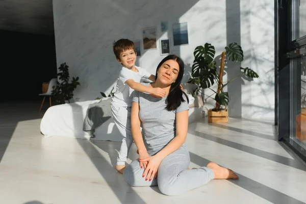 funny mom and son on the floor in the living room, concept motherhood and emotions