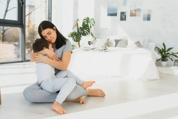 Alegre Madre Sentada Sofá Acogedora Sala Estar Luz Aferra Las — Foto de Stock