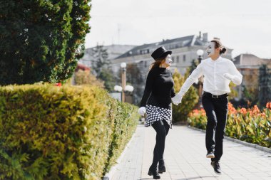 Birkaç neşeli pandomimci. Randevu için acele ediyor..