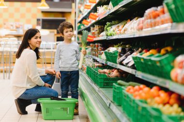 Kadın ve çocuk süpermarkette aile alışverişi yaparken