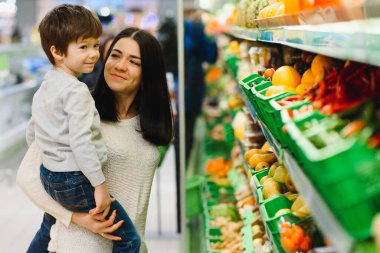 Kadın ve çocuk süpermarkette aile alışverişi yaparken