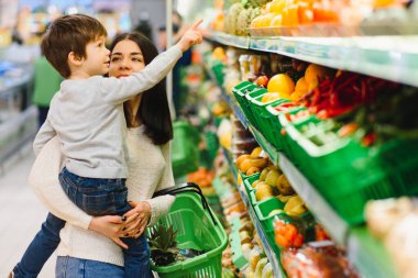 Kadın ve çocuk süpermarkette aile alışverişi yaparken