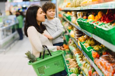 Genç anne ve küçük oğlu süpermarkette. Sağlıklı yeme kavramı