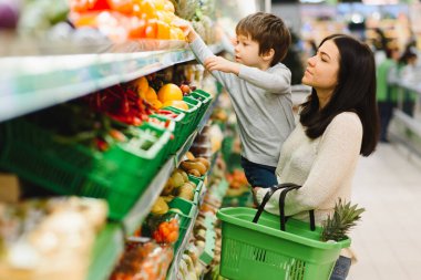 Kadın ve çocuk süpermarkette aile alışverişi yaparken