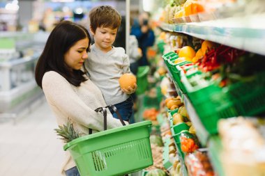 Kadın ve çocuk süpermarkette aile alışverişi yaparken