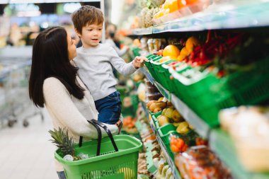Kadın ve çocuk süpermarkette aile alışverişi yaparken