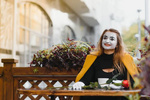 girl mime drinks coffee in paris. Mime comedian drinking coffee.