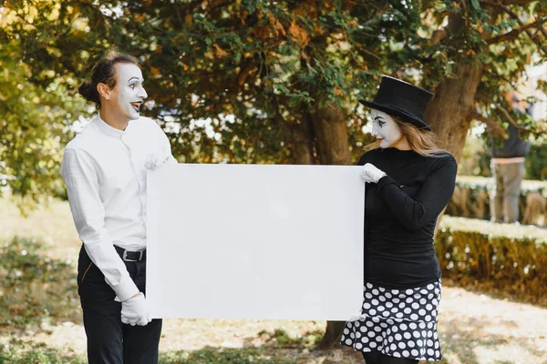 couple funny mimes holding sign