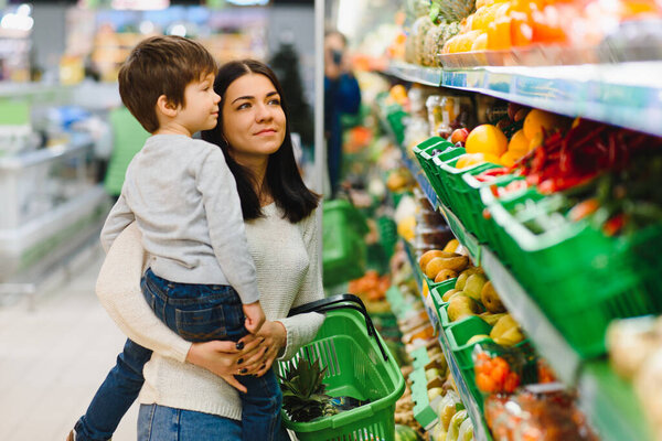 mother and her son buying fruits at a farmers market