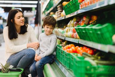 Kadın ve çocuk süpermarkette aile alışverişi yaparken