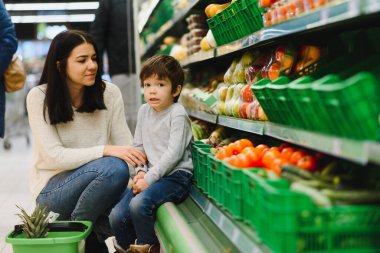 Genç anne ve küçük oğlu süpermarkette. Sağlıklı yeme kavramı