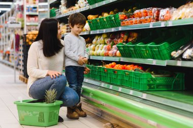 Kadın ve çocuk süpermarkette aile alışverişi yaparken