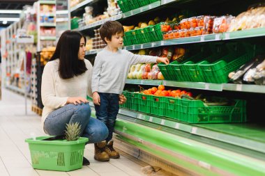 Kadın ve çocuk süpermarkette aile alışverişi yaparken