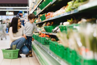 Kadın ve çocuk süpermarkette aile alışverişi yaparken
