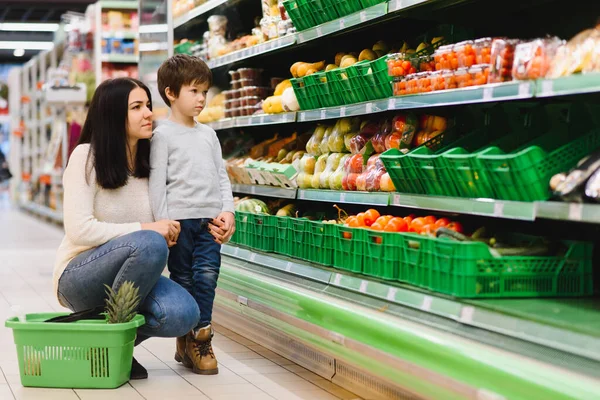 Genç anne ve küçük oğlu süpermarkette. Sağlıklı yeme kavramı