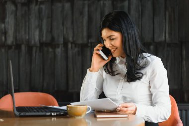 Şirin ticari şirket temsilcisi kadın model esmer büyük bina lobisinde gülümsüyor.