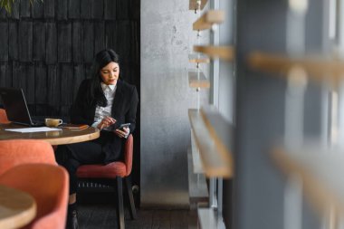 Ofiste dizüstü bilgisayarla çalışan bir iş kadını. Genç ve çekici bir iş kadını ofiste çalışıyor.