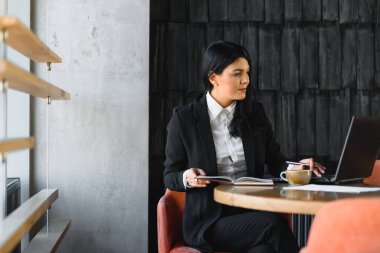 Ofiste dizüstü bilgisayarla çalışan bir iş kadını. Genç ve çekici bir iş kadını ofiste çalışıyor.