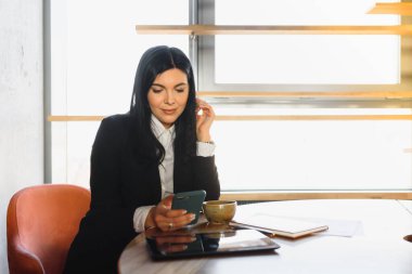 Şirin ticari şirket temsilcisi kadın model esmer büyük bina lobisinde gülümsüyor.