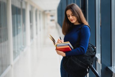 Gülümseyen kız öğrenci düzenli derslere katılarak geleceğini geliştiriyor.