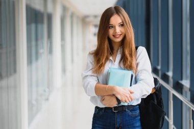 Gülümseyen kız öğrenci düzenli derslere katılarak geleceğini geliştiriyor.