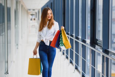 Moda Alışveriş Kızı Portresi. Alışveriş merkezinde alışveriş torbalarıyla gezen güzel kadın. Alışverişçi. Satışlar. Alışveriş Merkezi