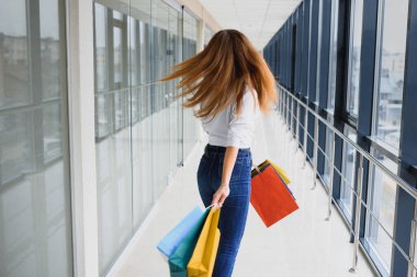 Moda Alışveriş Kızı Portresi. Alışveriş merkezinde alışveriş torbalarıyla gezen güzel kadın. Alışverişçi. Satışlar. Alışveriş Merkezi