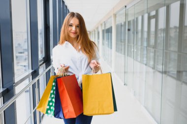 Moda Alışveriş Kızı Portresi. Alışveriş merkezinde alışveriş torbalarıyla gezen güzel kadın. Alışverişçi. Satışlar. Alışveriş Merkezi