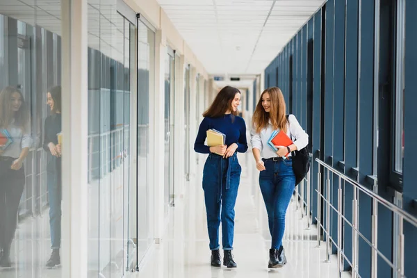 Dos Jóvenes Estudiantes Pie Con Libros Bolsas Pasillo Universidad Hablando —  Fotos de Stock