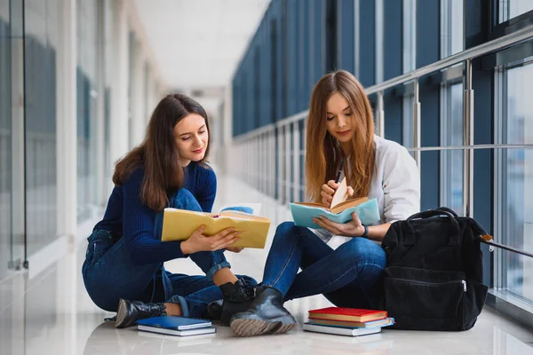 Dos Hermosas Estudiantes Femeninas Con Libros Sentados Suelo Pasillo Universidad —  Fotos de Stock