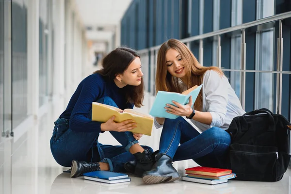 Dvě Krásné Studentky Knihami Podlaze Univerzitní Chodbě — Stock fotografie