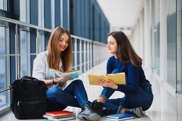 Δύο Όμορφες Φοιτήτριες Βιβλία Που Κάθονται Στο Πάτωμα Στο Διάδρομο — Φωτογραφία Αρχείου