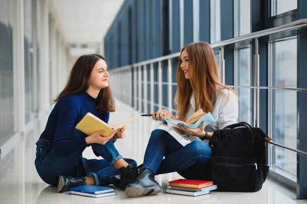 Dvě Krásné Studentky Knihami Podlaze Univerzitní Chodbě — Stock fotografie