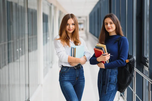 Dwie Młode Kobiety Książkową Pogawędką Stojące Korytarzu Koledżu Studenci Uczelni — Zdjęcie stockowe