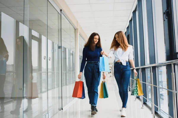 带着包和女友在商场里散步和购物的女孩 — 图库照片