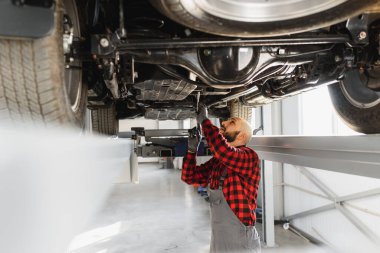 Otomobil tamircisinde çalışan bir tamirci.