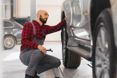 Otomobil tamircisinde çalışan bir tamirci.