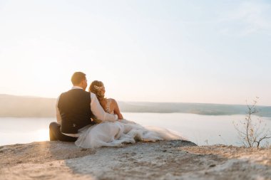 Sunset Romantik Evli Çiftte Gelin ve Damat. Gün batımında deniz kenarında bir çift gelin