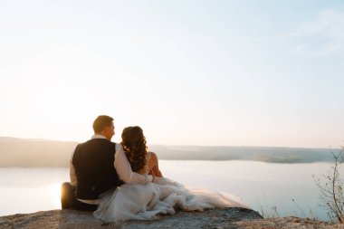 Sunset Romantik Evli Çiftte Gelin ve Damat. Gün batımında deniz kenarında bir çift gelin