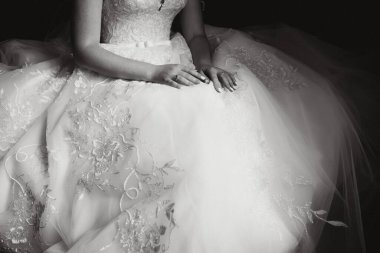 Nedime, ince gelinin beyaz elbisesini giymesine yardım ediyor, ince dantel desenli düğmelerini ilikliyor ve belinde tüylü bir etek var. Sabah gelini hazırlıkları yeni evlilerin detaylarını içeriyor. Düğün anları, giyin.