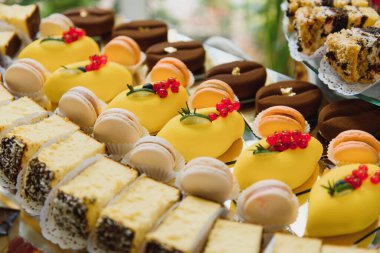 Meyveli tatlılar, krema, bisküvi. Farklı tatlı hamur işleri, küçük renkli tatlı kekler, makaron ve tatlı büfedeki diğer tatlılar. Doğum günü için çikolata.