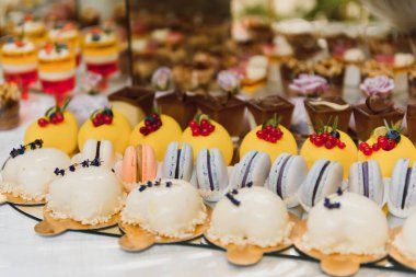 Meyveli tatlılar, krema, bisküvi. Farklı tatlı hamur işleri, küçük renkli tatlı kekler, makaron ve tatlı büfedeki diğer tatlılar. Doğum günü için çikolata.