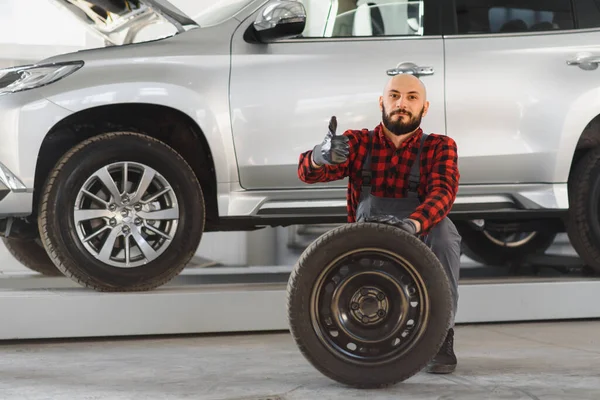 Mecânico Segurando Pneu Garagem Reparo Substituição Pneus Inverno Verão — Fotografia de Stock