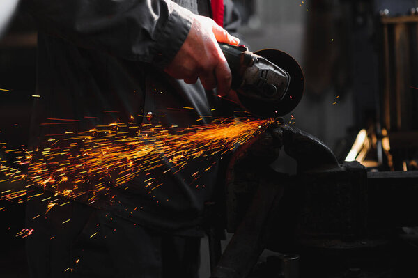 sawing metal. sparks frying over the working table during metal grinding