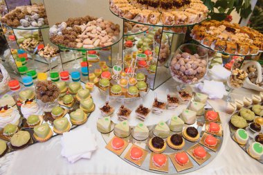 Meyveli tatlılar, krema, bisküvi. Farklı tatlı hamur işleri, küçük renkli tatlı kekler, makaron ve tatlı büfedeki diğer tatlılar. Doğum günü için çikolata.