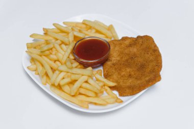 Beyaz arka planda patates kızartması sosu ve pirzola.