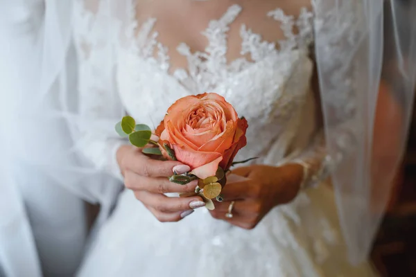 Bride and groom holding rose close up