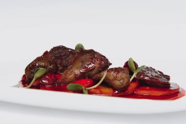 Taze bitki ve kiraz soslu et, beyaz arka planda yemeye hazır.