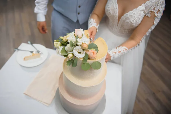 結婚式のケーキのスライスの花嫁と新郎の手 — ストック写真